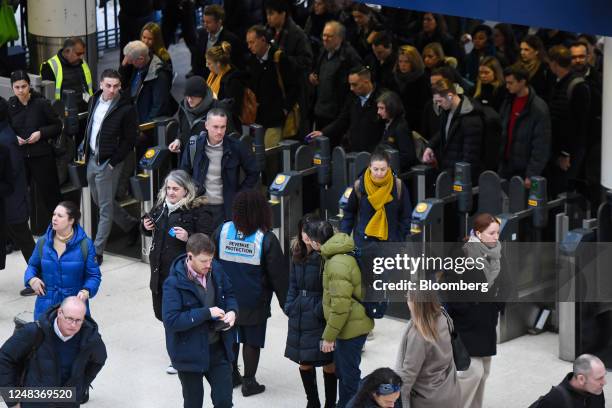 Commuters pass through the ticket barriers, during a rail workers strike, at London Waterloo railway station in London, UK, on Thursday, March 16,...