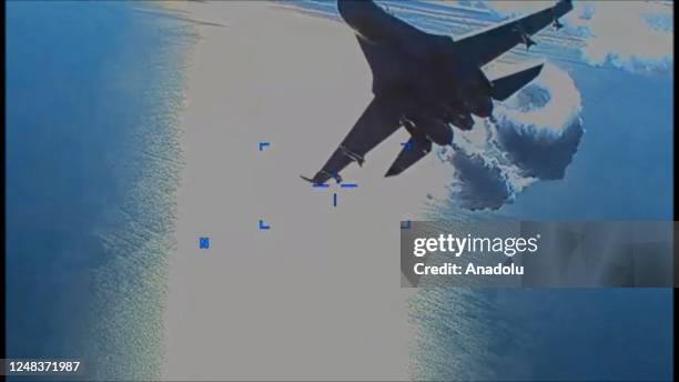 Screen grab captured from a video shows US drone is being harassed by Russian Su-27 fighter jet over Black Sea before it was downed on March 14,...