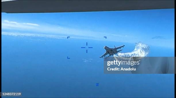 Screen grab captured from a video shows US drone is being harassed by Russian Su-27 fighter jet over Black Sea before it was downed on March 14,...