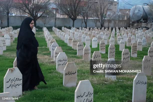 Kurdish woman walks amongst the graves, of those killed in the Halabja chemical attack in 1988, during a march to commemorate the 35th anniversary of...