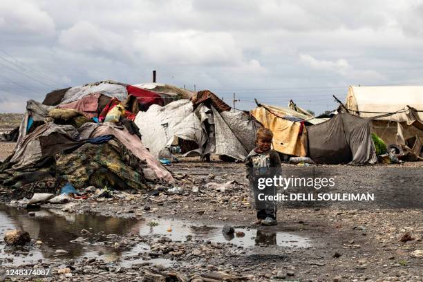 Child stands in front of tents damaged by floodwater inside the Sahlat al-Banat camp for internally displaced people, in the countryside of Raqa in...