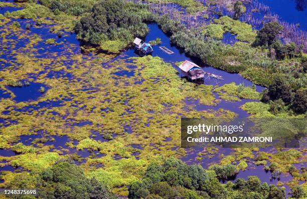 This picture taken 02 November 2007 shows two huts, build on natural peatland, are seen in Kampar, Riau. Peatland which is dense, swampy forest that...