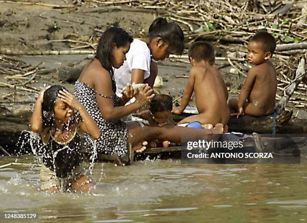 Brazilian Indians of the Ticunas tribe swim on the banks of the Solimoes River, 28 October 2000, in the Anzol Base, near Amazonia, Brazil.AFP...