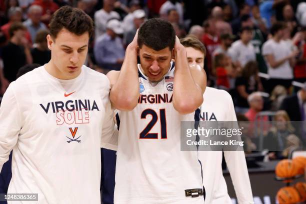 Francisco Caffaro and Kadin Shedrick of the Virginia Cavaliers walk off the court following their loss to the Furman Paladins in the first round of...