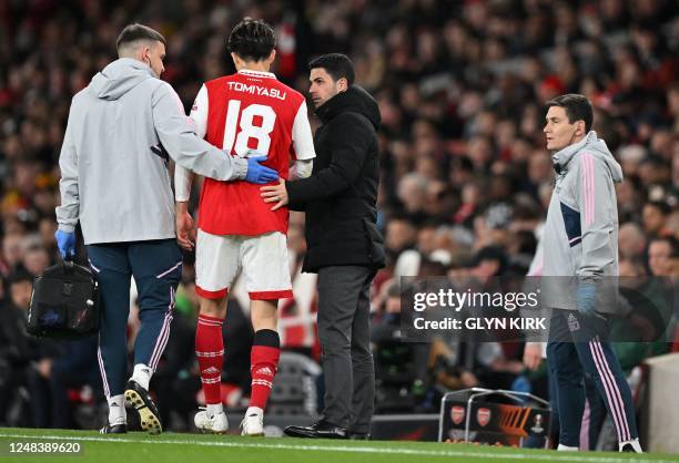 Arsenal's Japanese defender Takehiro Tomiyasu leaves the pitch injured during the UEFA Europa League round of 16, second-leg football match between...