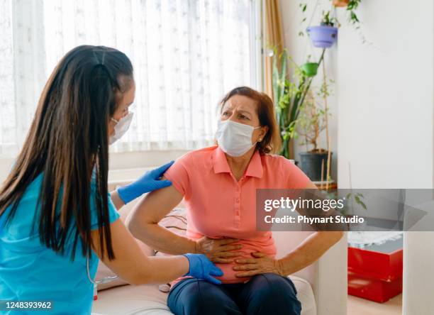 femme patiente de douleur abdominale ayant l’examen médical avec le docteur sur la maladie du cancer de l’estomac, syndrome du côlon irritable, malaise pelvien, indigestion, diarrhée, gerd (maladie de reflux gastro-oesophagien) - gastroentérite photos et images de collection