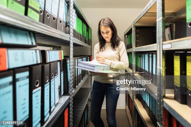 vrouwelijke business accountant controlling documenten in finance file archive - archive the office stockfoto's en -beelden