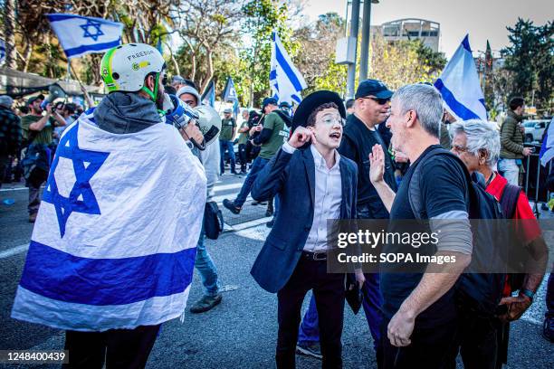 An Ultra orthodox youth argues with a protestor from the Brothers in Arm reserve soldiers movement during a protest against the Judicial reform in...