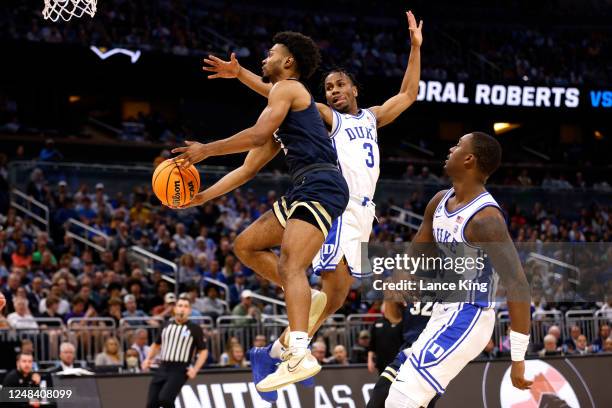 Issac McBride of the Oral Roberts Golden Eagles goes to the basket against Jeremy Roach of the Duke Blue Devils during the second half in the first...