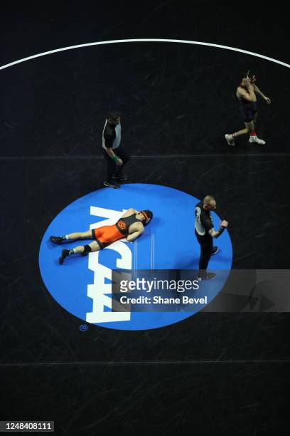 Oklahoma States Reece Witcraft lays on the mat as Pennsylvania Ryan Miller walks off during the Division I Men's Wrestling Championship held at the...