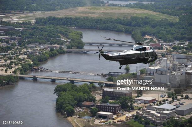 Presidential helicopter flies above a damaged bridge on June 19, 2008 in Cedar Rapids, Iowa. US President George W. Bush is in Iowa to survey flood...