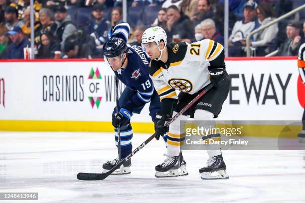 David Gustafsson of the Winnipeg Jets and Garnet Hathaway of the Boston Bruins get set during a first period face-off at the Canada Life Centre on...