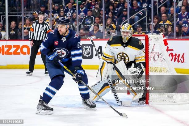 Nino Niederreiter of the Winnipeg Jets and goaltender Jeremy Swayman of the Boston Bruins keep an eye on the play during first period action at the...