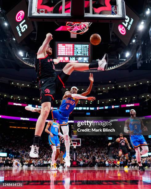 Jakob Poeltl of the Toronto Raptors dunks against Shai Gilgeous-Alexander of the Oklahoma City Thunder during the first half of their basketball game...