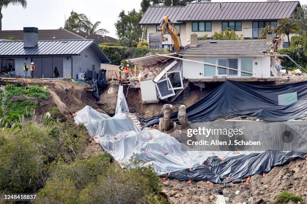 Newport Beach, CA Windows and debris crash down the hillside as crews demolish the final remaining walls on a red-tagged Newport Beach home owned by...