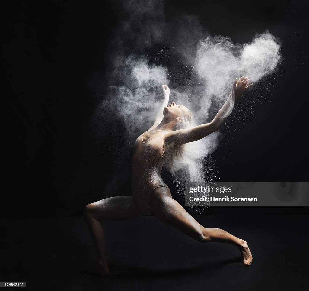 Young dancer performing with white powder