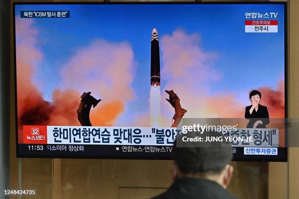 Man watches a television news screen showing a picture of North Korea's recent test-firing of a Hwasong-17 intercontinental ballistic missile , at a...