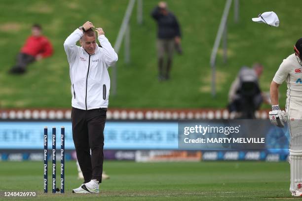 Umpire Chris Gaffaney has his hat blown off in strong winds on day one of the second Test cricket match between New Zealand and Sri Lanka at the...