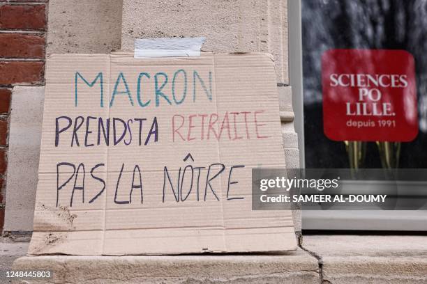 Placard reading "Macron, go for your retirement, not ours" is seen outside the Institute of Political Studies , which is blocked by students who...