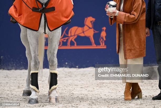 Luxembourg's Victor Bettendorf receives his price after winning the Prix du Grand Palais at the Saut-Hermes 2023, set in the Grand Palais Ephemere,...