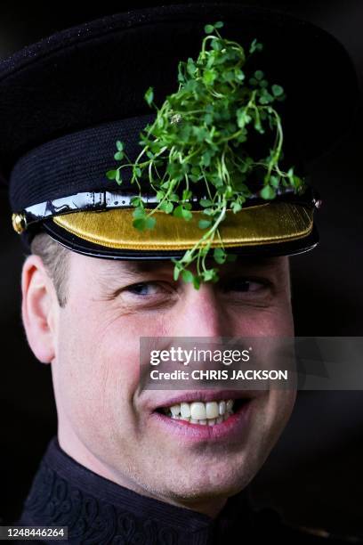 Britain's Prince William, Prince of Wales with a sprig of traditional Shamrock in his cap, reacts during a visit to the 1st Battalion Irish Guards...