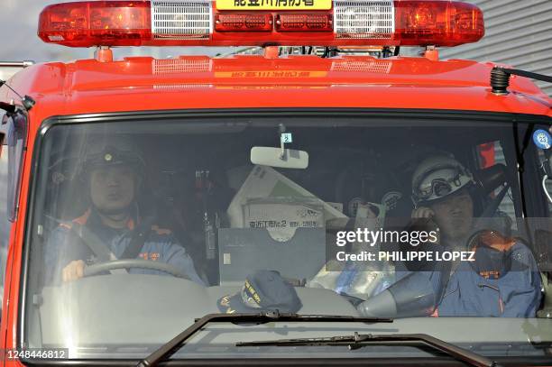 Japanese firemen drive through Fukushima on March 13, 2011 following the massive earthquake and tsunami. An explosion at a reactor of the Fukushima...