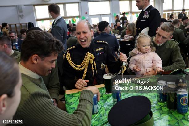Britain's Prince William, Prince of Wales sits with a pint of Guinness with members of the 1st Battalion Irish Guards following their St Patrick's...