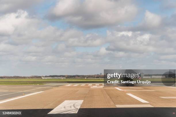 airplane approaching amsterdam airport - airport tarmac stock pictures, royalty-free photos & images