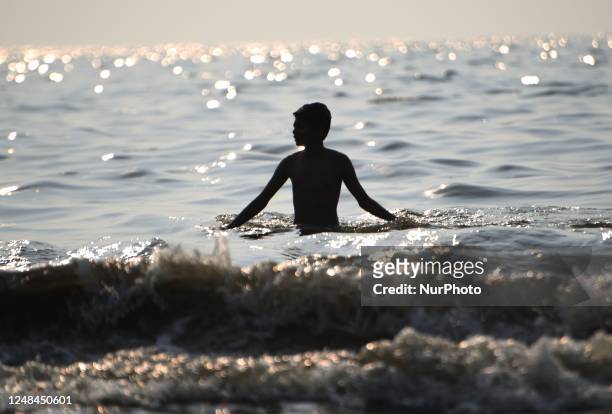 Boy relaxes in Arabian sea near a sea beach in Mumbai, India, 17 March, 2023.