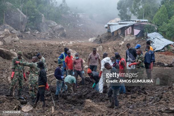 Malawi Defence Force, soldiers and civilians work to recover body of a victim of a mudslide which resulted due to heavy rains resulting from cyclone...