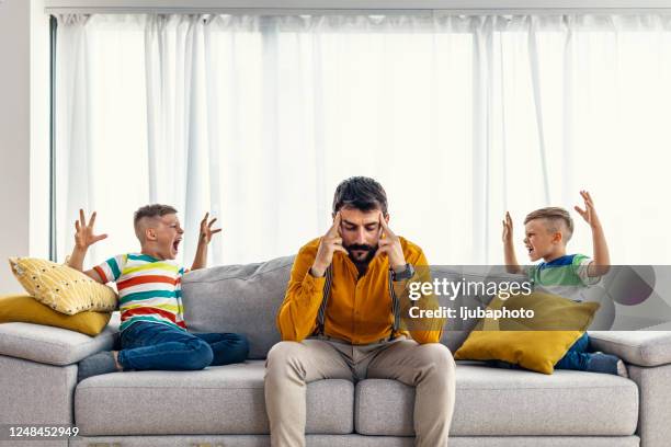 père célibataire déprimé fatigué des petits gosses bruyants - enfant crier photos et images de collection