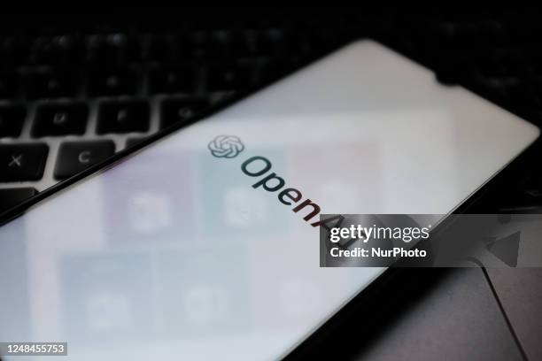 In this photo illustration an Open AI logo seen displayed on a smartphone screen and Microsoft Office 365 suite in the background. The technology...