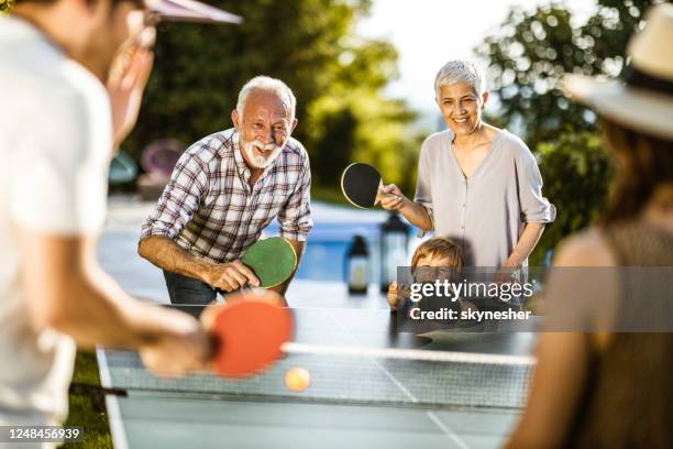 happy extended family having fun while playing table tennis in the backyard. - friends table tennis stock pictures, royalty-free photos & images