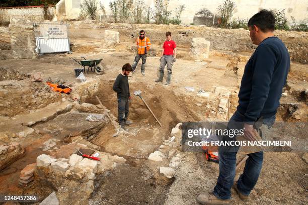 Archaeologists from the Institut National de Recherches Archeologiques Preventives work at an excavation site in Reims, northern France, on March 16...