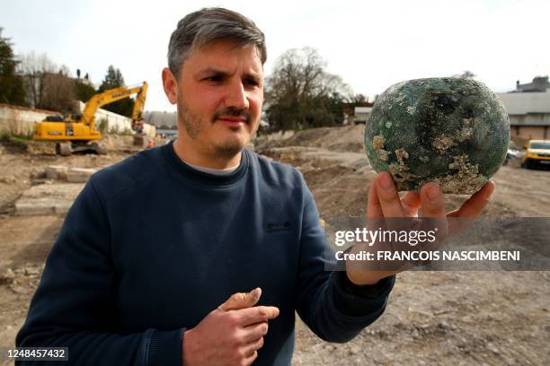 Yoann Rabaste, Scientific Director from the Institut National de Recherches Archeologiques Preventives shows a copper-alloy bowl found at an...