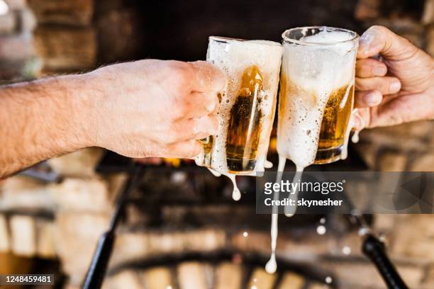 spilling beer during a toast! - beer splash stock pictures, royalty-free photos & images