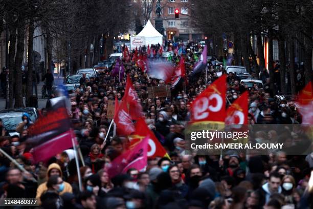 Protestors wave union flags as they march during a demonstration in Lille, northern France, on March 17 the day after the French government pushed a...