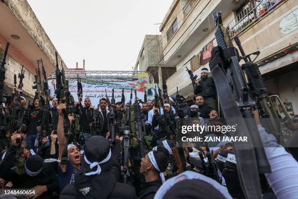 Palestinian gunmen from the Balata brigade of the Al-Aqsa Martyrs Brigades armed group, rally to mark the first anniversary of the killing of...