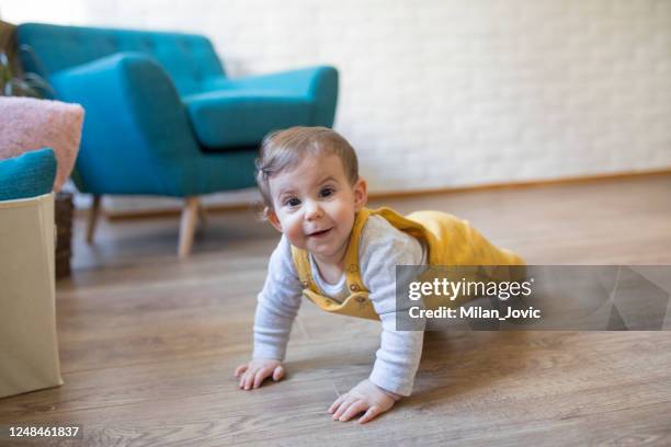 lindo bebé en amarillo - gatear fotografías e imágenes de stock