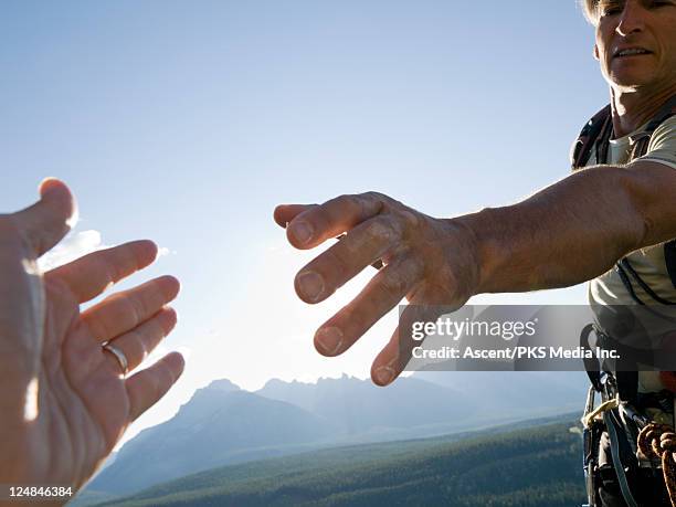 mountaineer stretches helping hand to teammate - climber hands bildbanksfoton och bilder