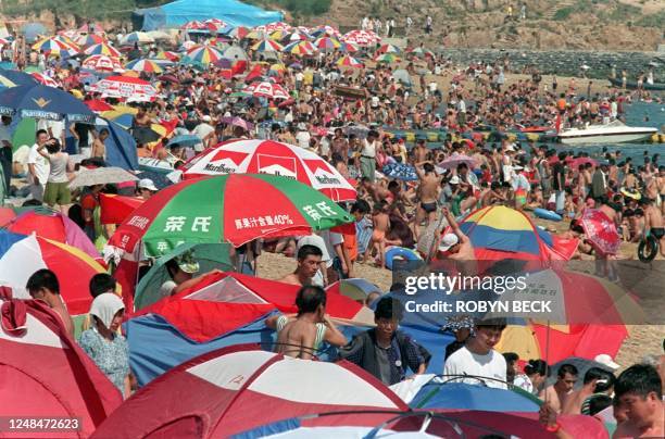 Umbrellas, tents and bodies crowd a popular beach in Dalian 19 July. Dalian, which at various times in the last century has been taken as colonial...