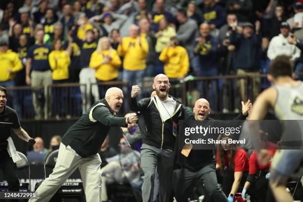 Purdue Head coach, Tony Ersland, holds back other coaches from the mat during the Matt Ramos of Purdue's win by fall over Spencer Lee of Iowa during...