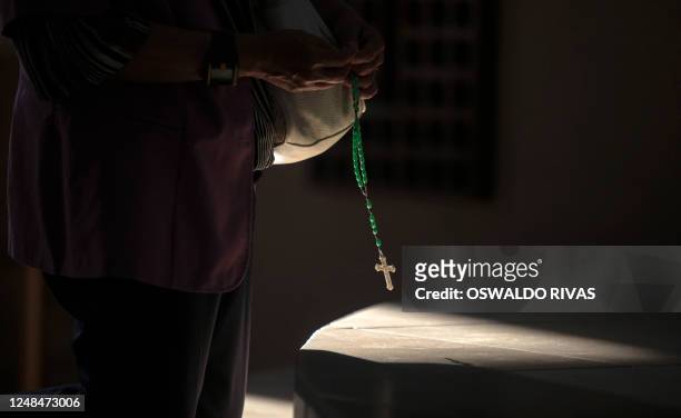 Woman prays before a Viacrucis at the Metropolitan Cathedral in Managua, on March 17, 2023.