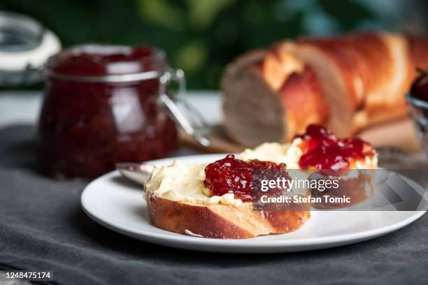 sandwich mit erdbeermarmelade mit margarine auf dem teller - marmalade sandwich stock-fotos und bilder