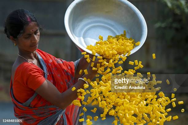 Worker lays "Finger Fryums" to dry, which is a finger shaped food made from seasoned dough, in a factory on the outskirts of Agartala, India on March...
