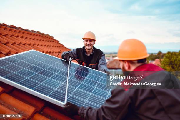 males checking solar panel width - houses in the sun stock pictures, royalty-free photos & images