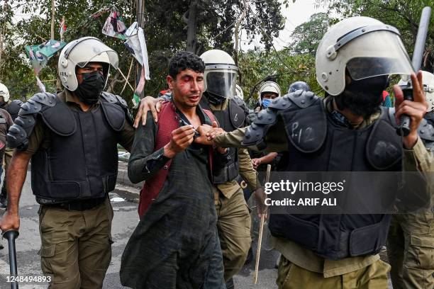 Riot police detain a suppoeter of former Pakistans prime minister Imran Khan in Lahore on March 18 after Khan left for Islamabad to appear in a...