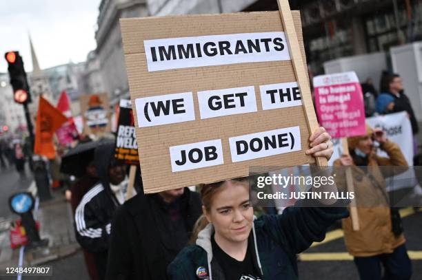 Protesters hold up placards as they take part in the Resist Racism March and Rally in central London on March 18 ahead of United Nations anti-racism...