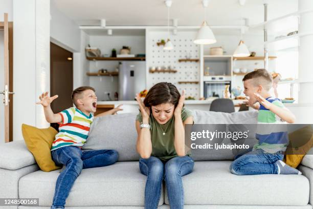 unhappy mother having problem with noisy naughty two kids - adhd child imagens e fotografias de stock