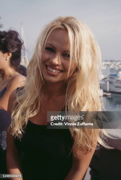 Canadian actress Pamela Anderson wearing a sleeveless black top with a scoop neckline, attends a 'Baywatch' cast party, held on Malibu Pier in...